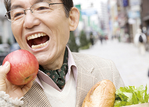 リンゴをかじる年配男性